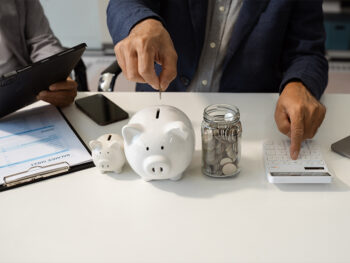 Homem guardando suas finanças na poupança em cofre com formato de porquinho