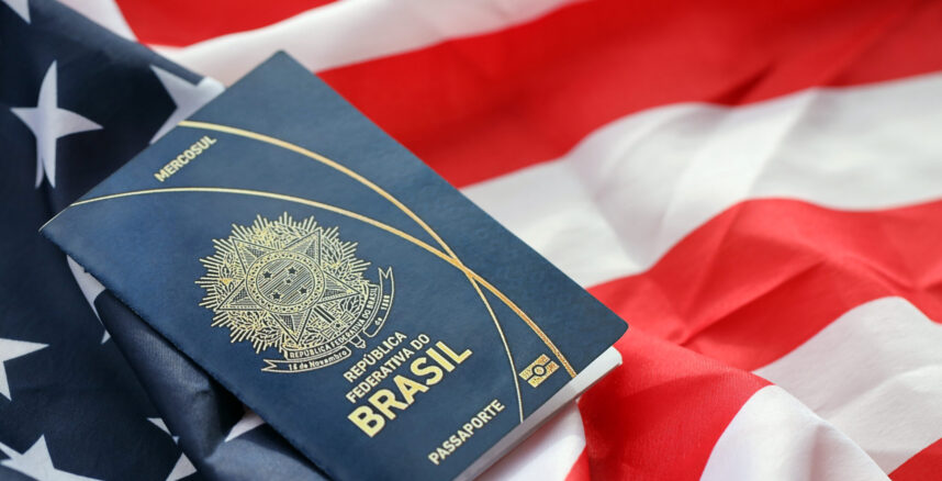 Blue Brazilian passport on United States national flag background close up pedro braggio como o tarifaco afeta os brasileiros nos eua scaled