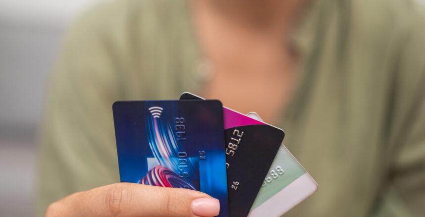 Close-up: Woman hand grasps stack of credit cards, symbolizing online payments, shopping pedro braggio credito ou debito scaled