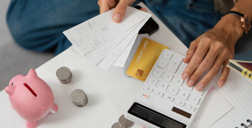 Financial Planning. Individual calculating expenses with receipts and a calculator. pedro braggio dividas o caminho para sair do vermelho 2025 scaled