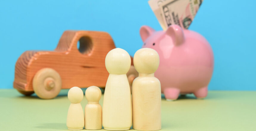 wooden little men family stands on the background of piggy bank pedro braggio o peso da pensao como equilibrar as financas scaled